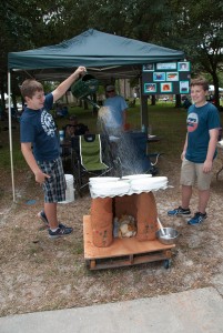 Student using watering can to "rain" on pet house.