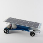 Model-sized solar electric car with sleek body design, painted blue and white.