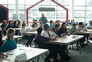 Four-member teams sit at a six-foot table, waiting for their question to be delivered.