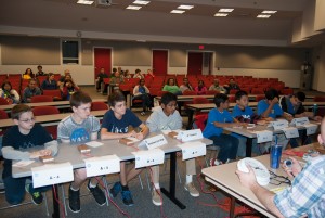 Students sitting at tables in double-elimination science bowl competition.