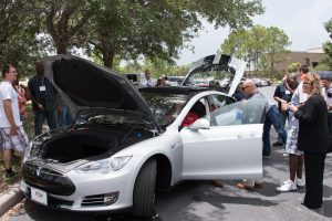 Tesla electric car (silver with black racing stripes) with all doors and hood opened for workshop participants to take a look.