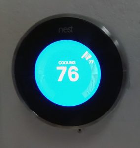 NEST thermostat reading 76 degrees installed on wall 