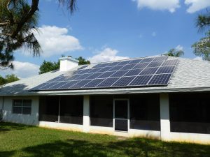 Rear view of house with screened in back porch and solar electric array with 36 panels on roof