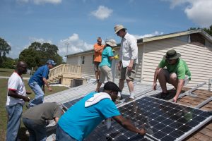 Adults students in the Installing Photovoltaic Systems course receive hands-on instruction and install PV panels on mock residential roof systems.