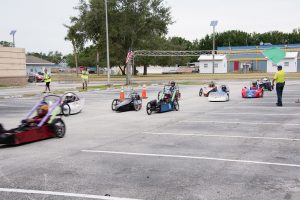 Nine electric go-carts racing at green flag