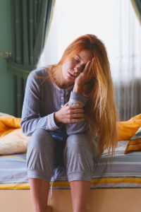 Young woman waking up in her bedroom