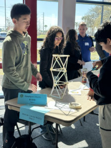 Students building tower out of straws.