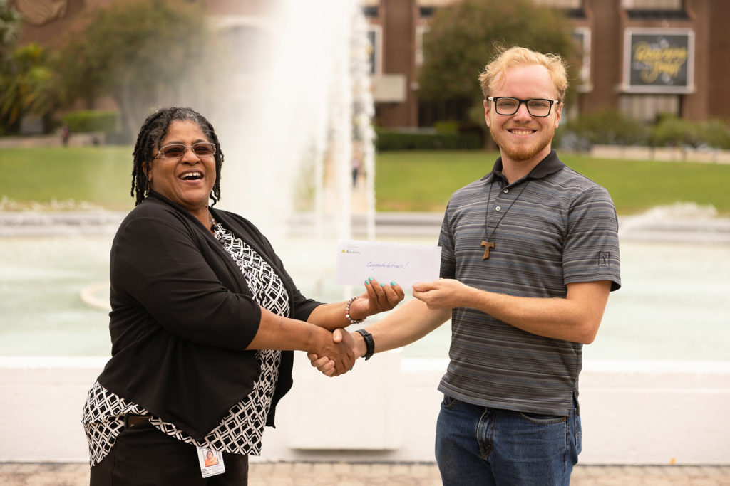 Monica Marlow, FEWC Board Member and Finance Chair, presents scholarship check to Timothy Gallagher, UCF engineering student and FSEC employee.