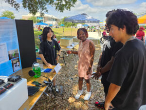 Three students talking with Critter Comfort Cottage project.
