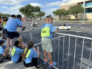 Student from Junior Solar Sprint competition watching Electrathon race trackside.