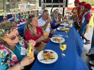 Four culinary judges taste-test food in front of students.